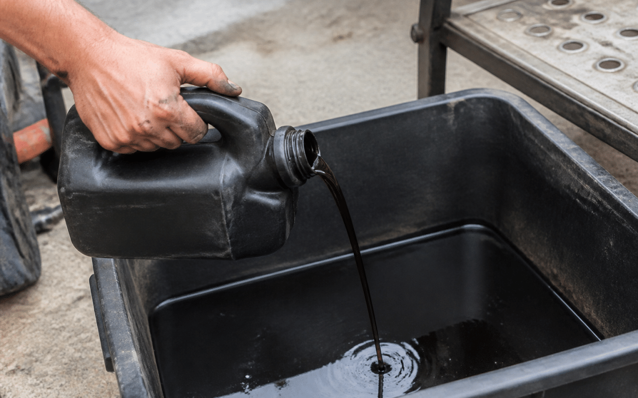Bidon d'huile usee verse dans un bac de recyclage