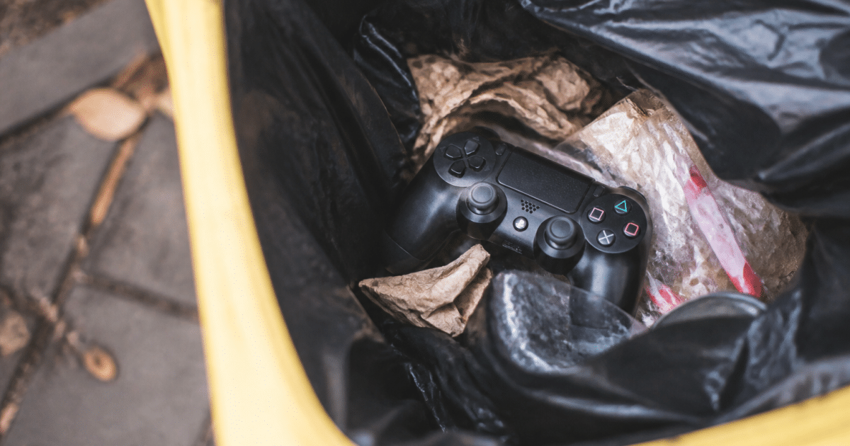 Manette de jeu posee dans une poubelle jaune