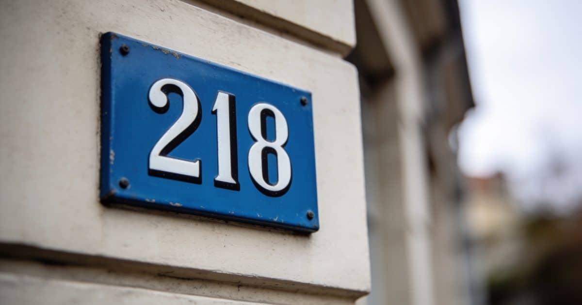 Panneau bleu avec numéro postal affichés sur façade.