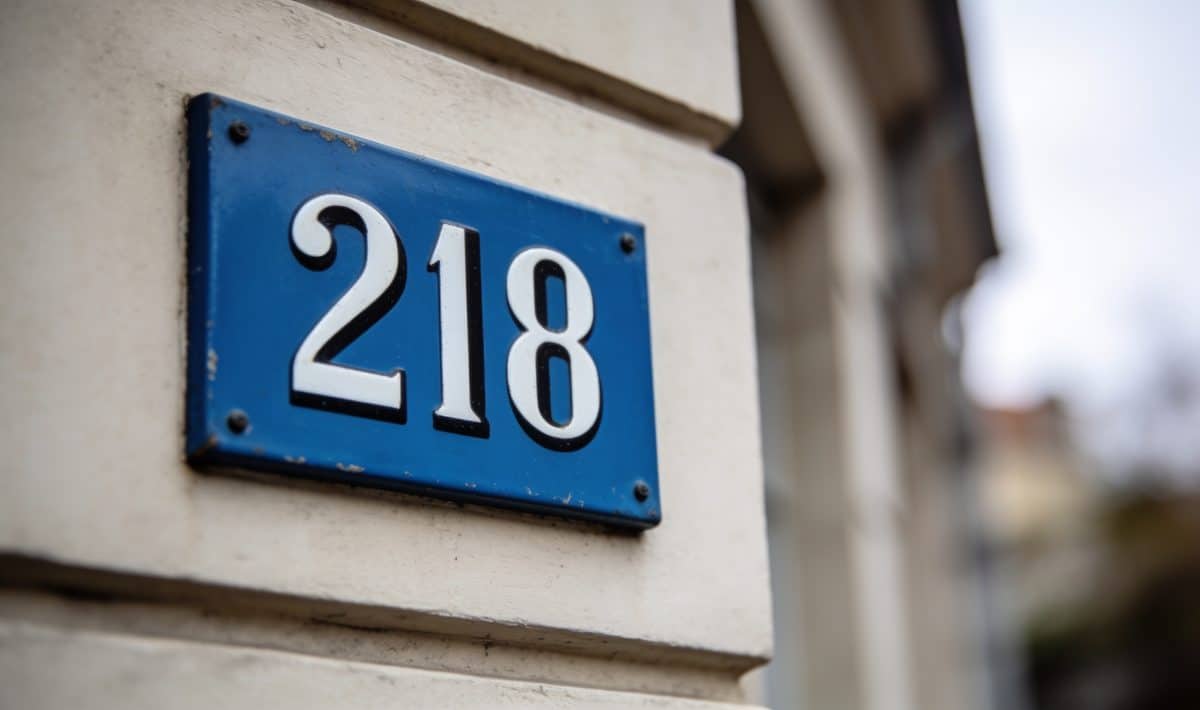 Panneau bleu avec numéro postal affichés sur façade.