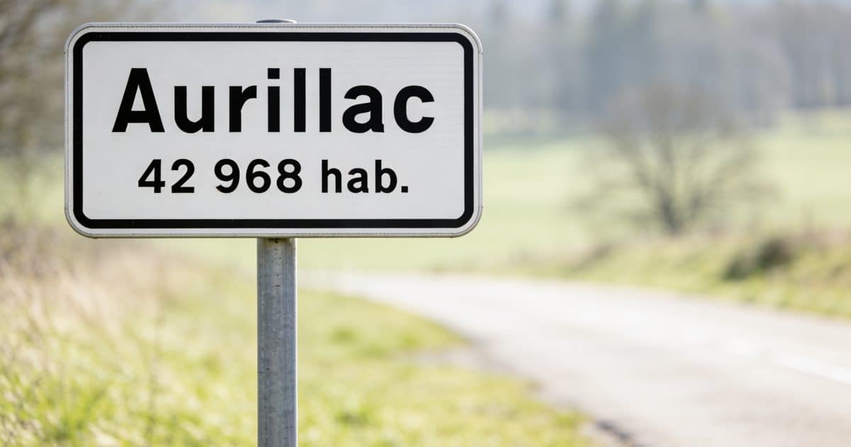 Panneau routier affichant le nom Aurillac avec chiffres population