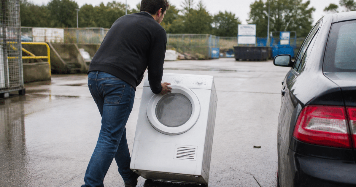 Personne deposant un seche-linge dans un centre recyclage