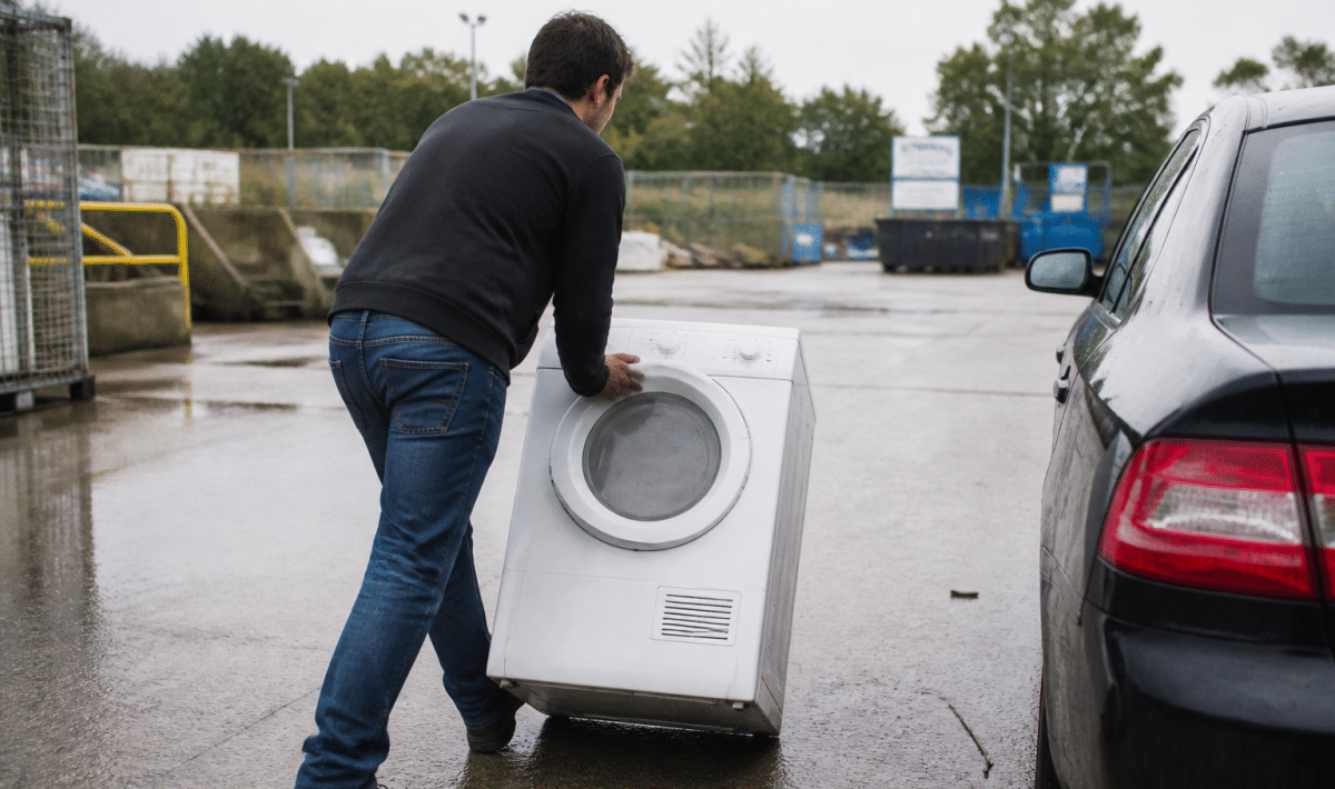 Personne deposant un seche-linge dans un centre recyclage