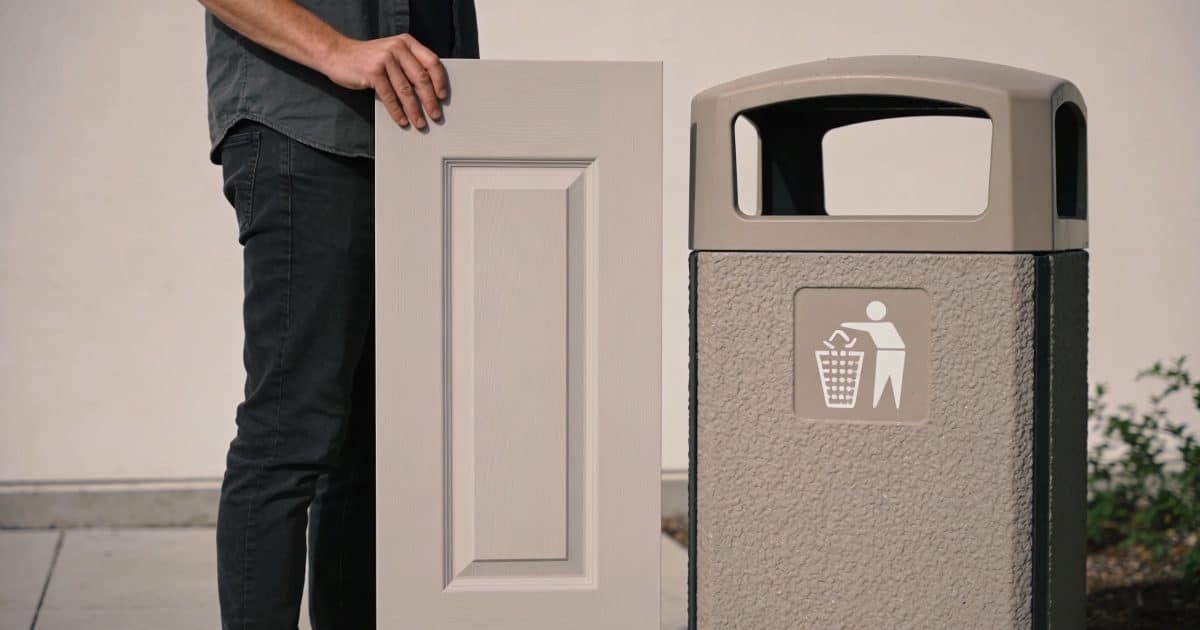 Personne tenant une porte verticale près conteneur recyclage