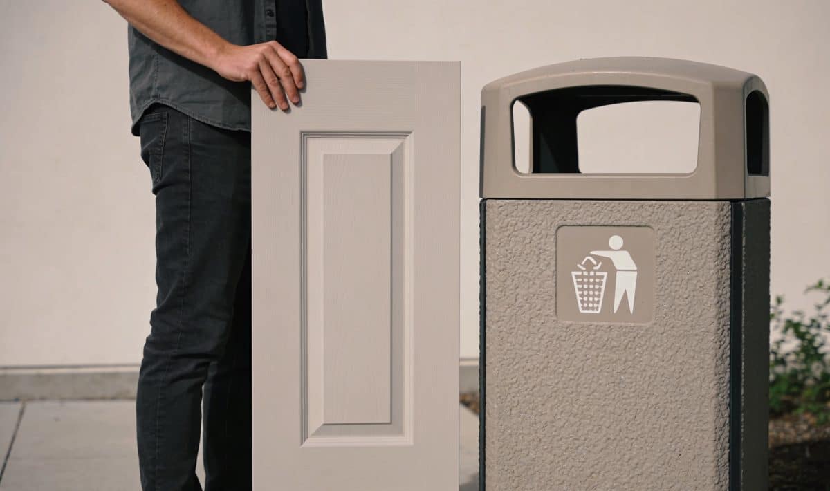 Personne tenant une porte verticale près conteneur recyclage