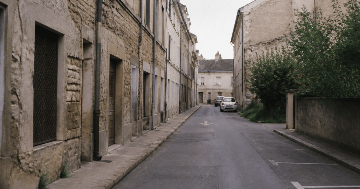 Rue déserte de Dijon avec immeubles dégradés et façades endommagées