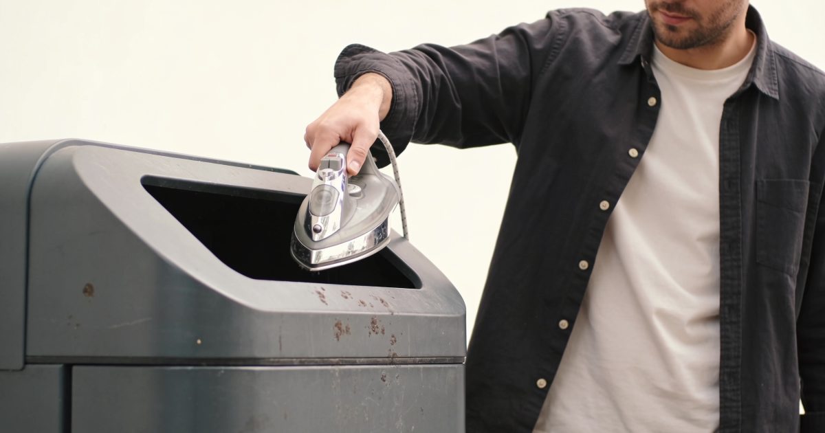 Homme deposant un fer metallique dans une poubelle