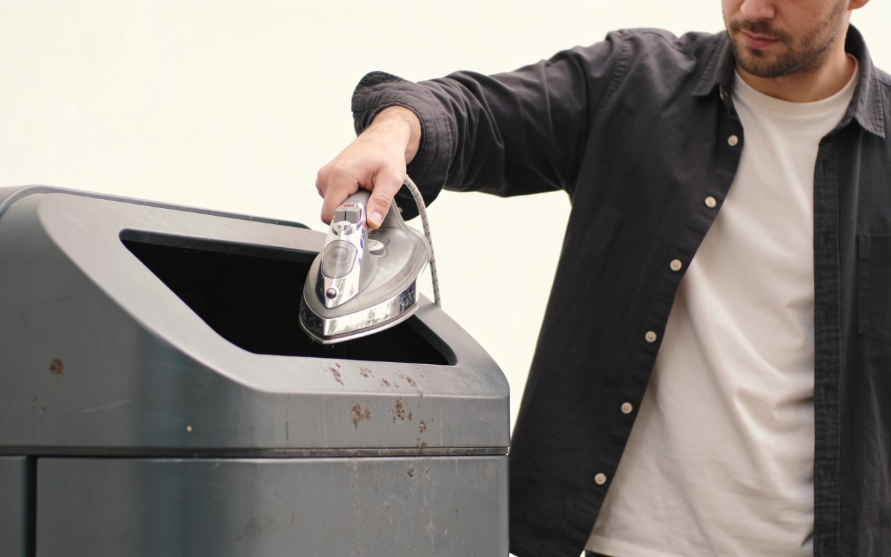 Homme deposant un fer metallique dans une poubelle