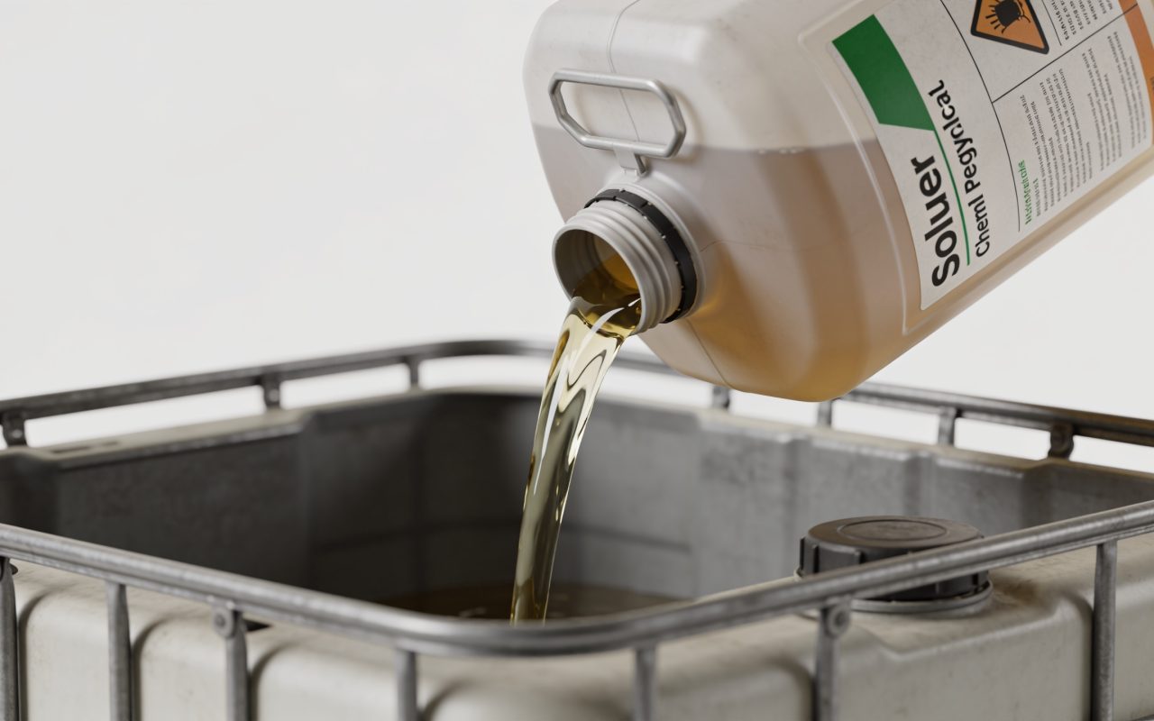 Bidon de solvant versé dans bac de recyclage chimique.